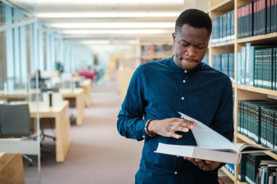 A student leafing through the pages of a law book